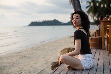 Fototapeta premium Young asian woman sitting on the tropical beach.