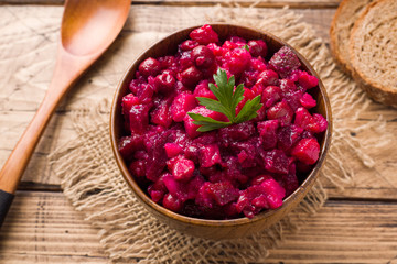 Fresh homemade beet salad vinaigrette in a wooden bowl. Traditional Russian food.
