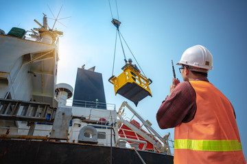 engineering, loading master connecting to gantry crane driver by walkie talkie for lifting safety...