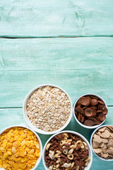 various cereals, nuts and dried fruits on wooden surface