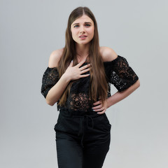 Concept portrait of a pretty beautiful brunette girl talking on a gray background in the studio...