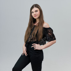 Concept portrait of a pretty beautiful brunette girl talking on a gray background in the studio standing