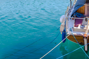 Fototapeta na wymiar Boat part on bright blue shallow sea in Greece