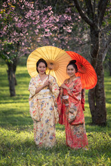 Fototapeta premium Asian woman wearing traditional japanese kimono with sakura