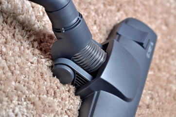 Close-up of head of vacuum cleaner on shaggy carpet - close-up of noozle