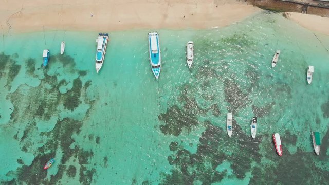 Sea reefs off the coast of the village of Lembongan with boats on the island of Nusa Lembongan. Indonesia. Aerial view.