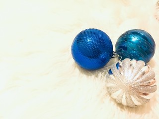 Snow falling against colored christmas balls on a carpet