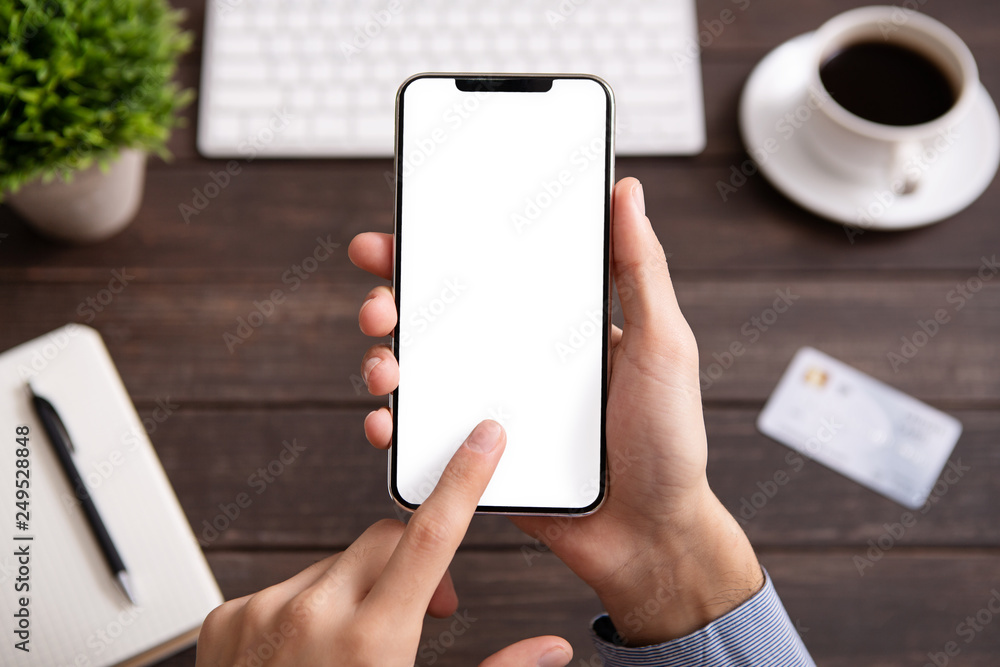 Poster man using blank smartphone on workplace desk