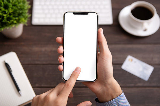Man using blank smartphone on workplace desk