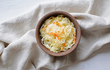 Top view of bowl of sauerkraut with cabbage on towel