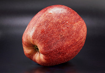 juicy ripe red apple on a dark background