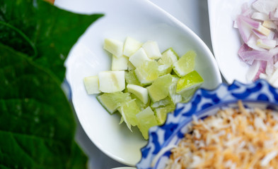 close up chopped lemon on white spoon for miang kum ingredient