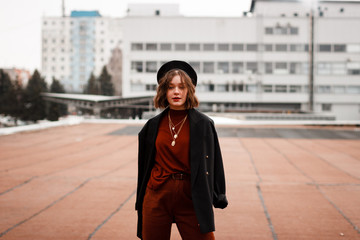 Obraz premium Stylish hipster girl in red sweater posing in the street