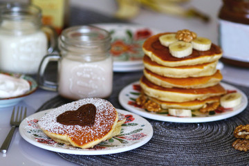 Breakfast pancakes served with honey and fruits and milk