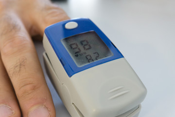 pulse oximeter with finger to measure saturation