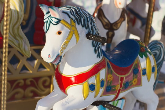 Outdoor colourful vintage flying horse carousel in the park