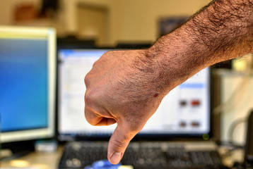 Male hand of Caucasian man makes thumbs down gesture.