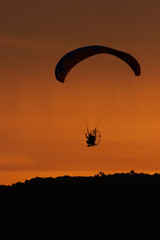 silhouette of paraglider at sunset