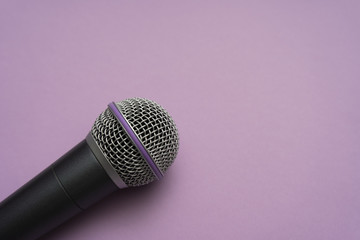 Close-up of vocal microphone laying on the purple surface