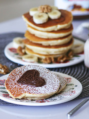 Breakfast pancakes served with honey and fruits and milk