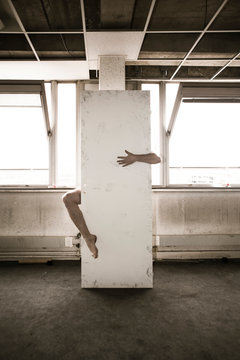 Bras et jambe derri&egrave;re une porte arrach&eacute;e