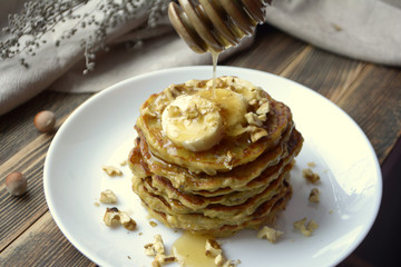 Stack of oatmeal pancake with banana, nuts and honey Healthy Breakfast	