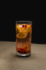 Glass with berry juice on the table on a black background.
