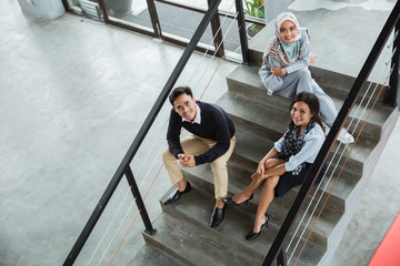 relax business people chatting in the office staircase together in working break