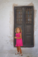 Small european tourist plays happy in the small town of Chora in Mykonos