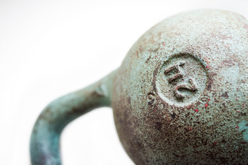 Old sports  kettlebell 24 kg on a white background, a close up, selective soft focus
