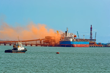 Loading bulk carrier ship with bauxite aluminum ore at Kamsar port, Guinea.