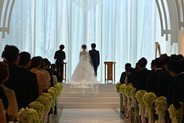 チャペルの結婚式で挙式を上げる新郎新婦