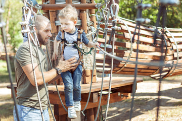 Little cute boy overcomes an obstacle.
