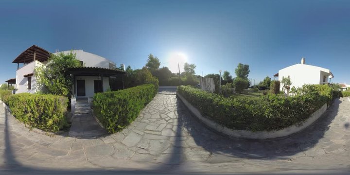 360 VR Video. Paved path running between the cottages at Trikorfo Beach summer resort. Living in villas with green nature around