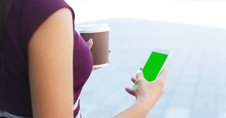 Woman using smartphone with green screen