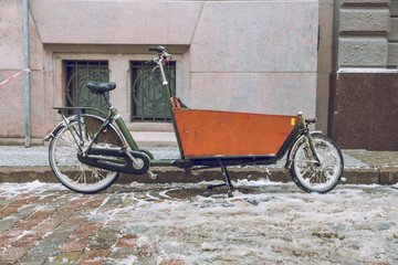 Fototapeta na wymiar Old bicycle, green color, urban city street. Snow and cold weather. Travel photo 2019.