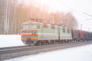 Obraz premium Freight train hauled by diesel locomotive winter landscape