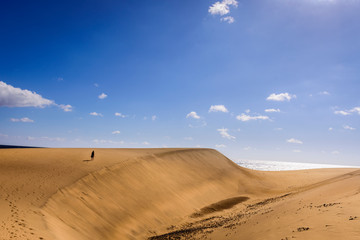 woman walking on dunes in maspalomas, spain
