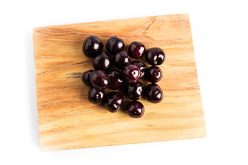 group of fresh red cherries on a wooden board