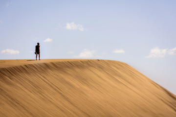 Obraz premium woman walking on dunes in maspalomas, spain