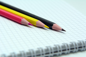 colored pencils lying on a spiral notepad