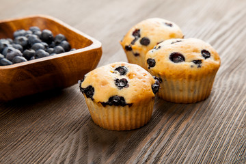 muffin with blueberries on a wooden table. fresh berries and sweet pastries on the board.