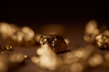 selective focus of golden stone on blurred dark background