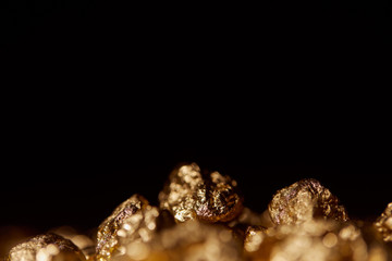 Obraz na płótnie Canvas selective focus of gold stones isolated on black