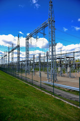 Obraz premium High-voltage tower on green grass and sky in background. - Image