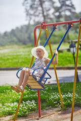 Cute girl swinging on teeter-totter at kids playground