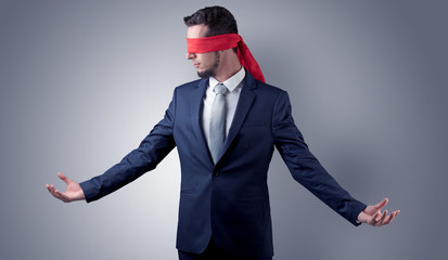 Covered eye, indecisive businessman standing blind in front of a wall
