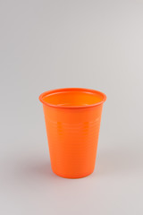 Round orange Plastic Cup isolated on grey background