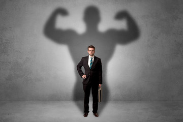 Obraz premium Lovely serious businessman standing with a muscular powerful shadow behind his back 