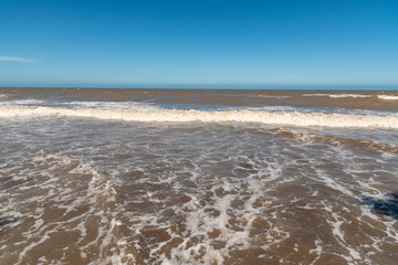 Empty beach in Argentina with high tide with clear sky